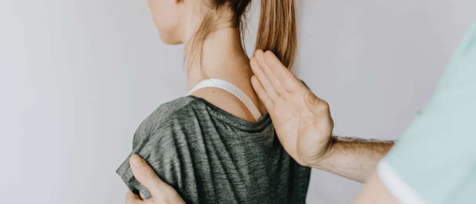 Athlete's shoulder being checked by hand