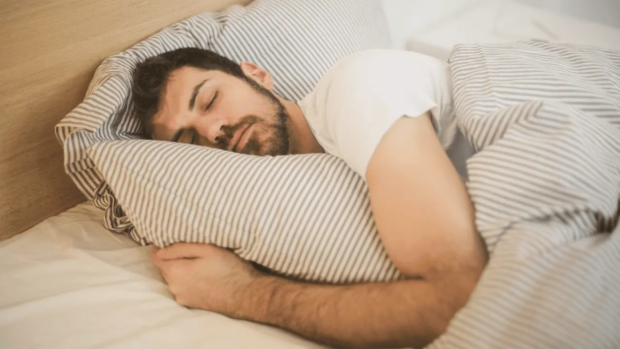 Mann schläft entspannt in einem hellen Schlafzimmer